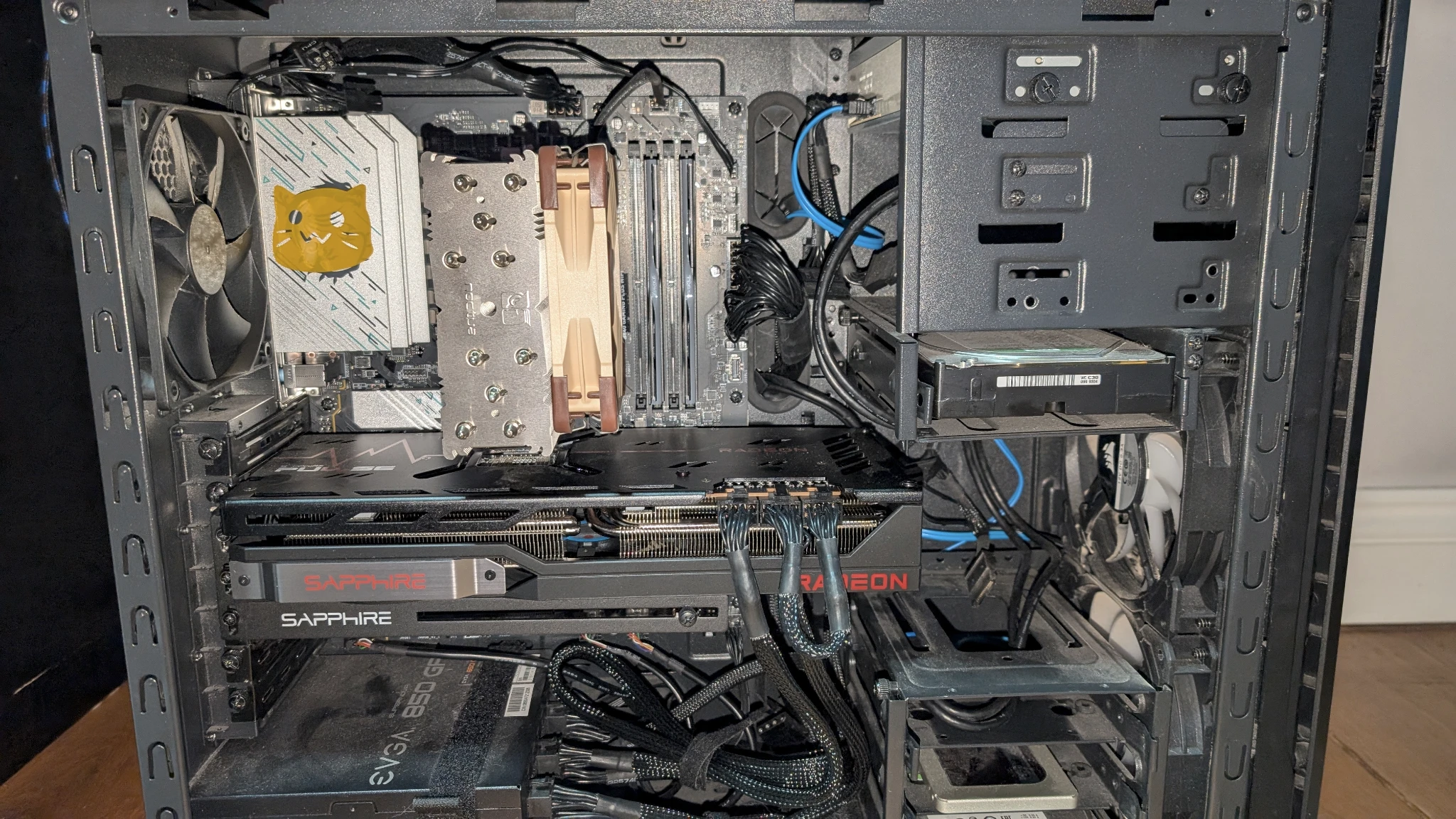 The built PC, now up-right with all components inserted, only one Blobcat sticker can be seen now, on a motherboard heatsink.