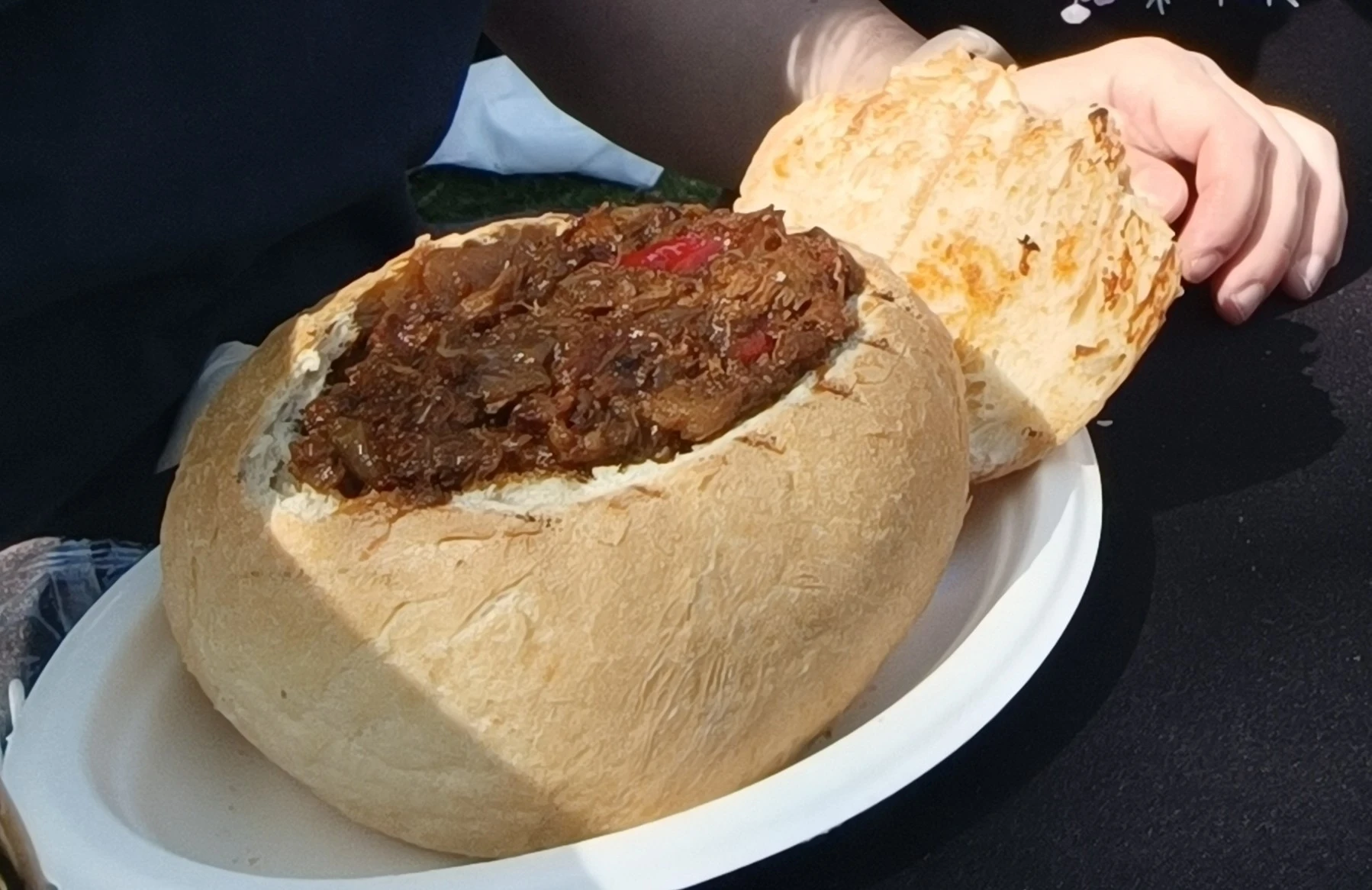 Chicken goulash served in a carved bread bun