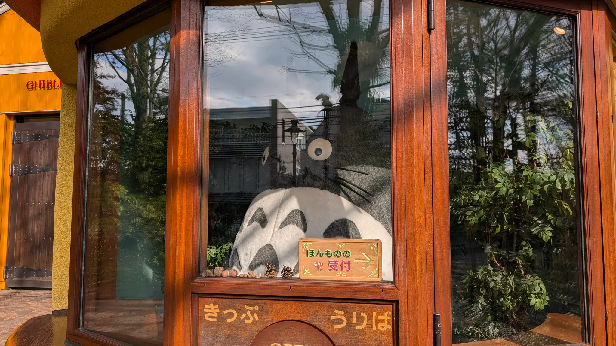 A huge Totoro statue inside a windowed room.